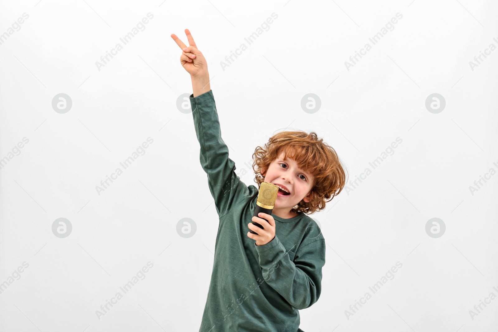 Photo of Little boy with microphone singing on white background