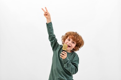 Photo of Little boy with microphone singing on white background