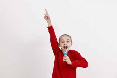 Photo of Little girl with microphone singing on white background