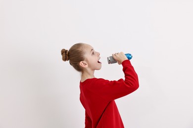 Photo of Little girl with microphone singing on white background