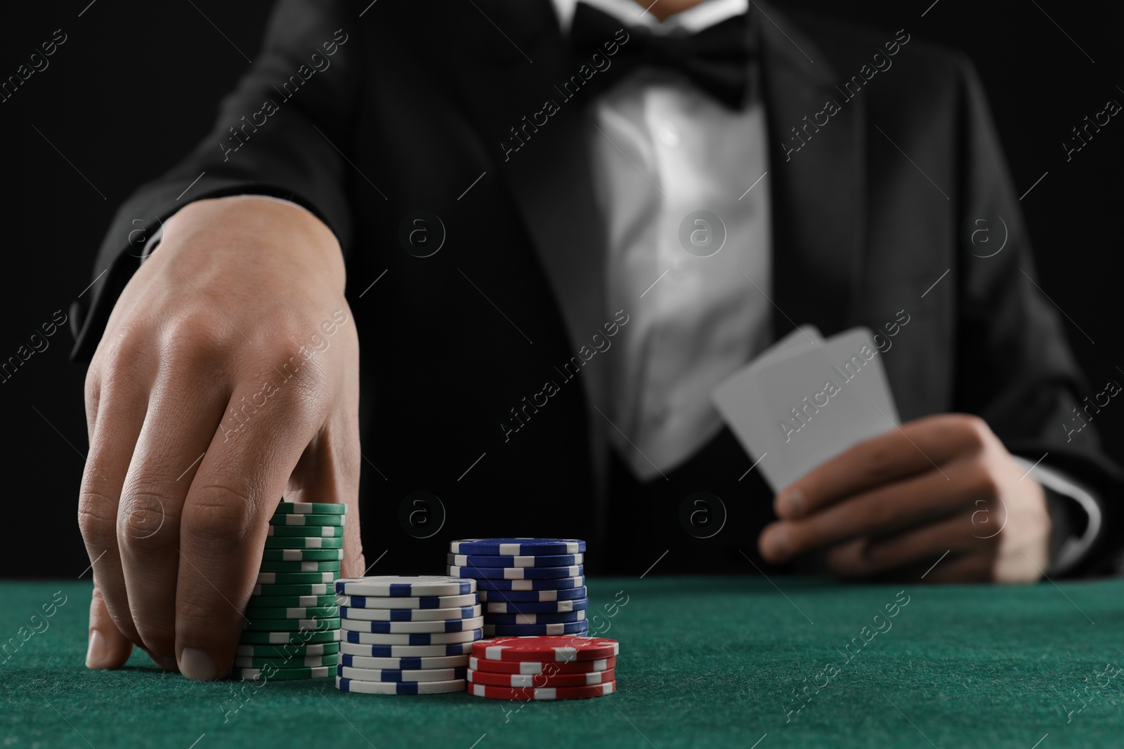 Photo of Man with cards and casino chips playing poker at gambling table, closeup