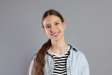 Photo of Portrait of smiling teenage girl on grey background