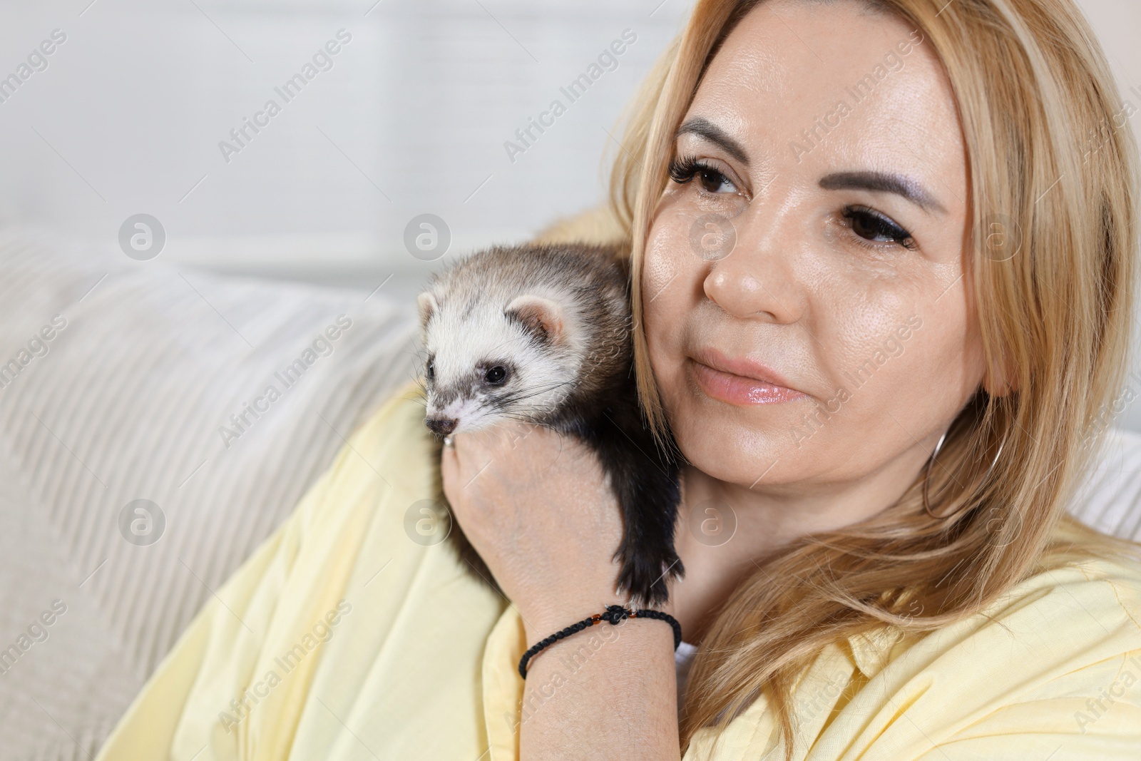 Woman with cute ferret at home, closeup. Space for text Photo of Woman with cute ferret at home, closeup. Space for text