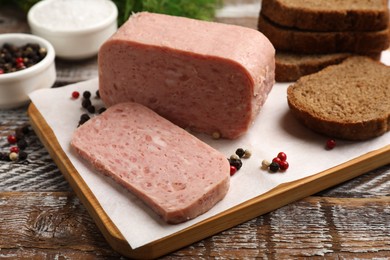 Photo of Canned meat, spices and bread on wooden table, closeup