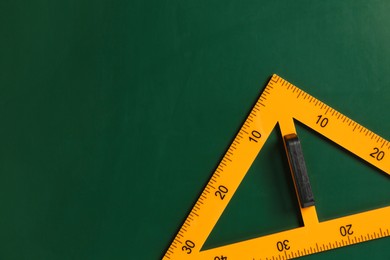 Photo of One triangle ruler on green chalkboard, top view. Space for text