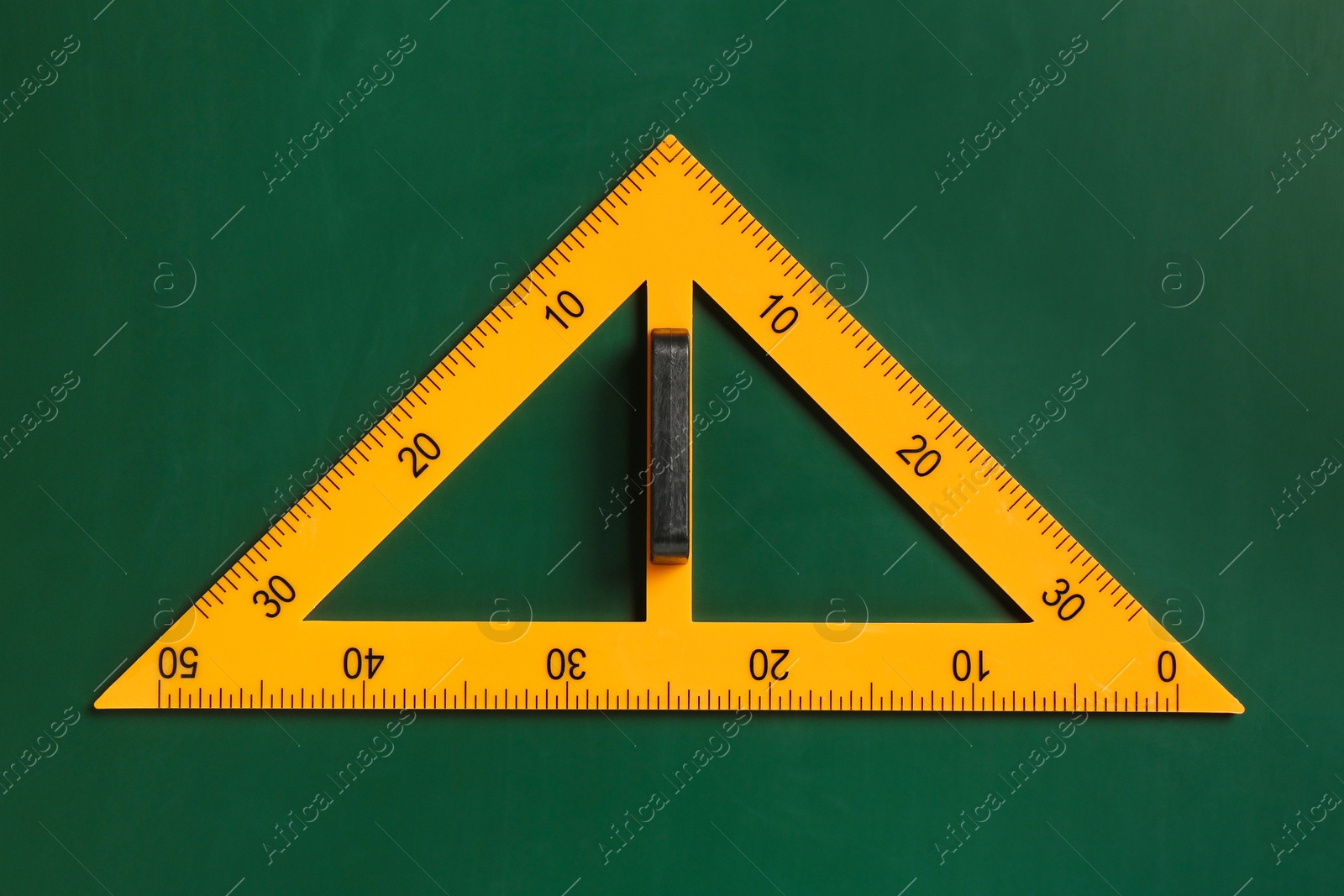 Photo of One triangle ruler on green chalkboard, top view