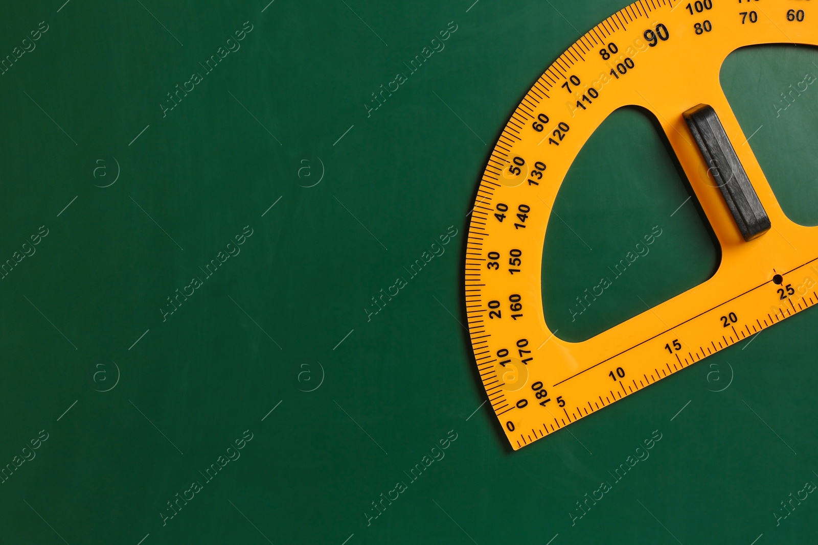 Photo of Protractor ruler on green chalkboard, top view. Space for text