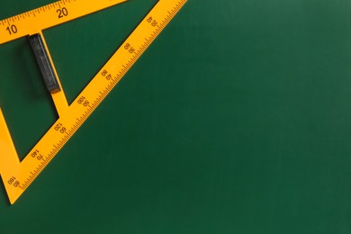 One triangle ruler on green chalkboard, top view. Space for text