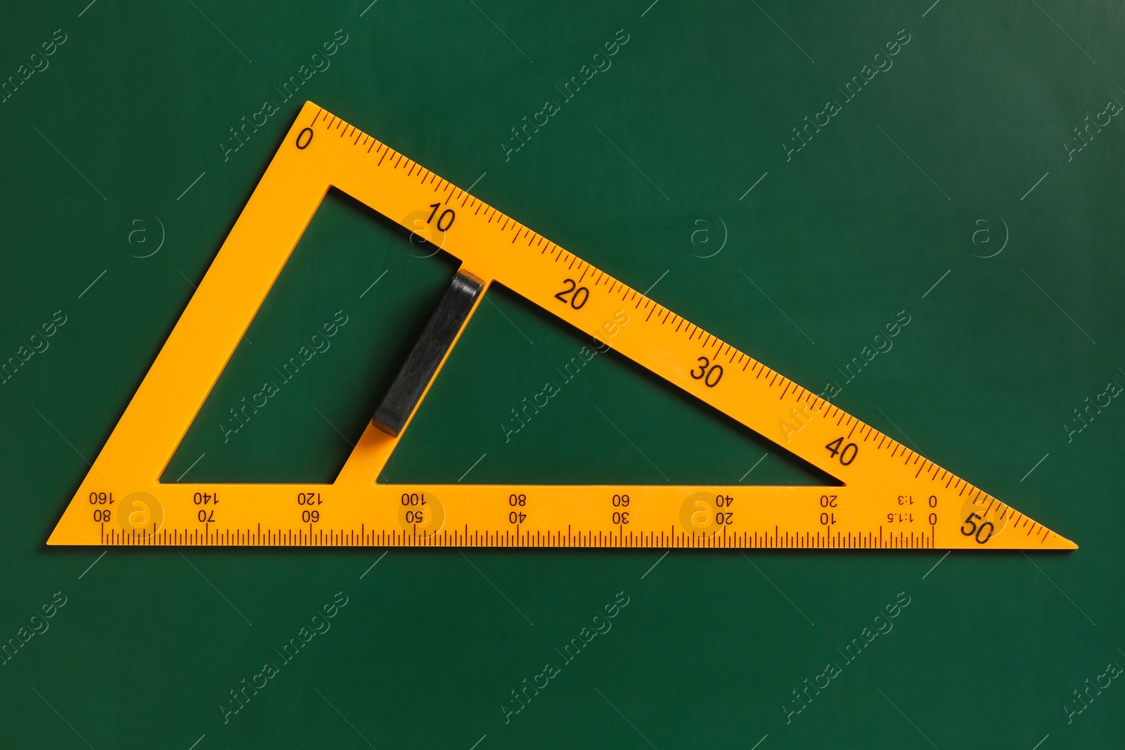 Photo of One triangle ruler on green chalkboard, top view