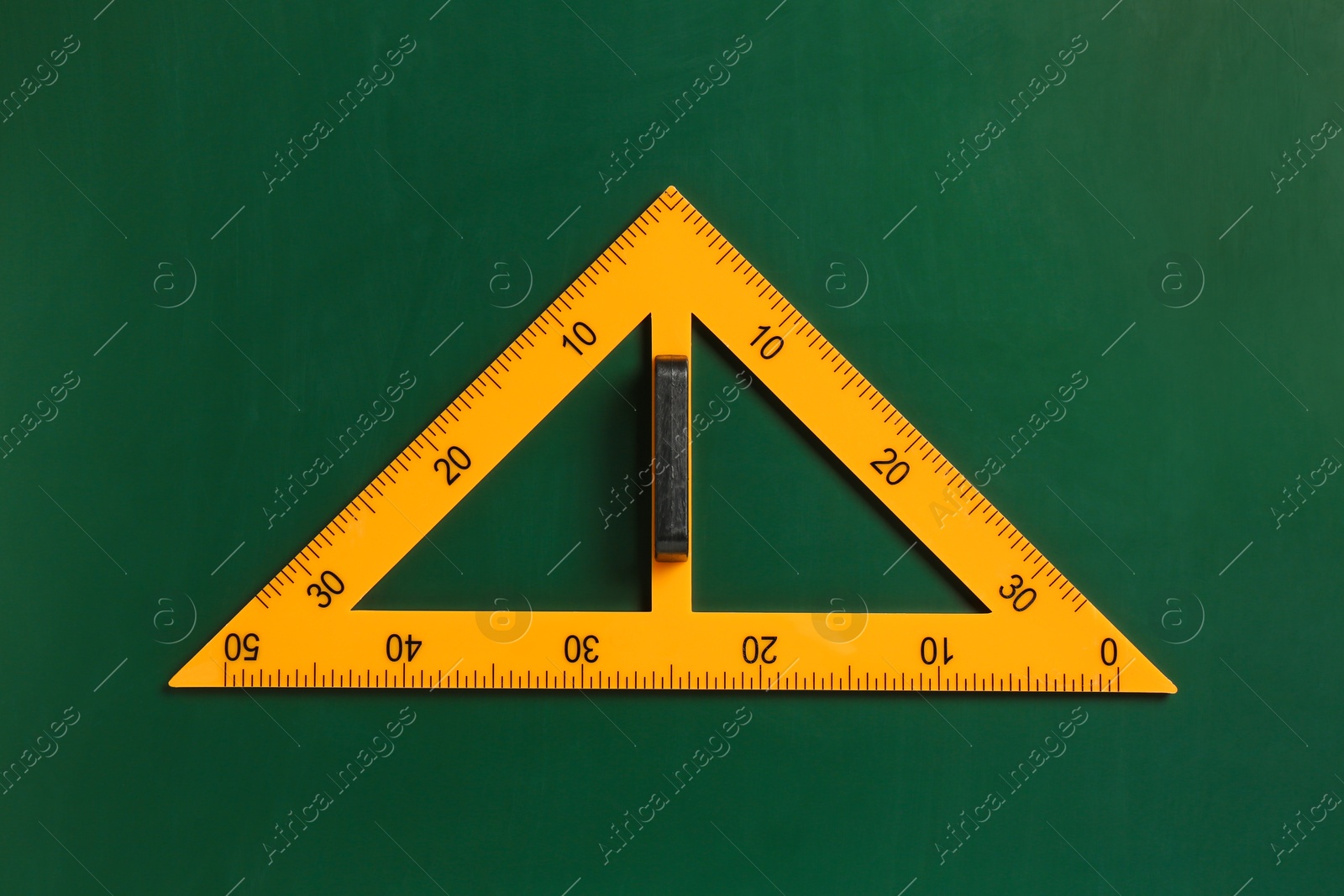 Photo of One triangle ruler on green chalkboard, top view