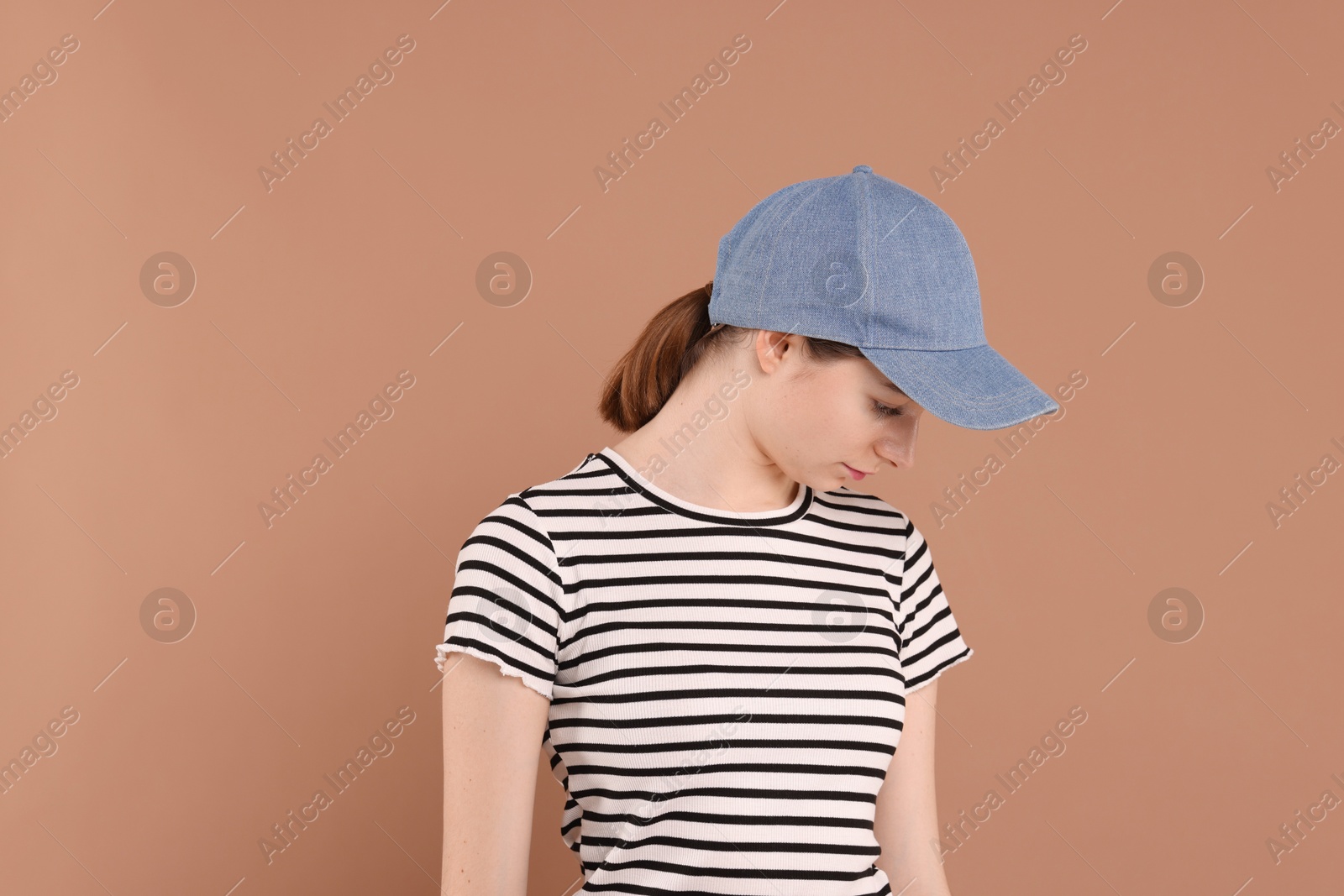 Photo of Woman in stylish baseball cap on beige background. Mockup for design