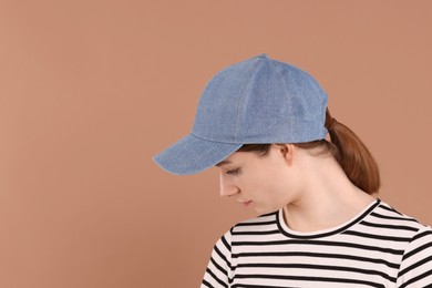 Photo of Woman in stylish baseball cap on beige background. Mockup for design