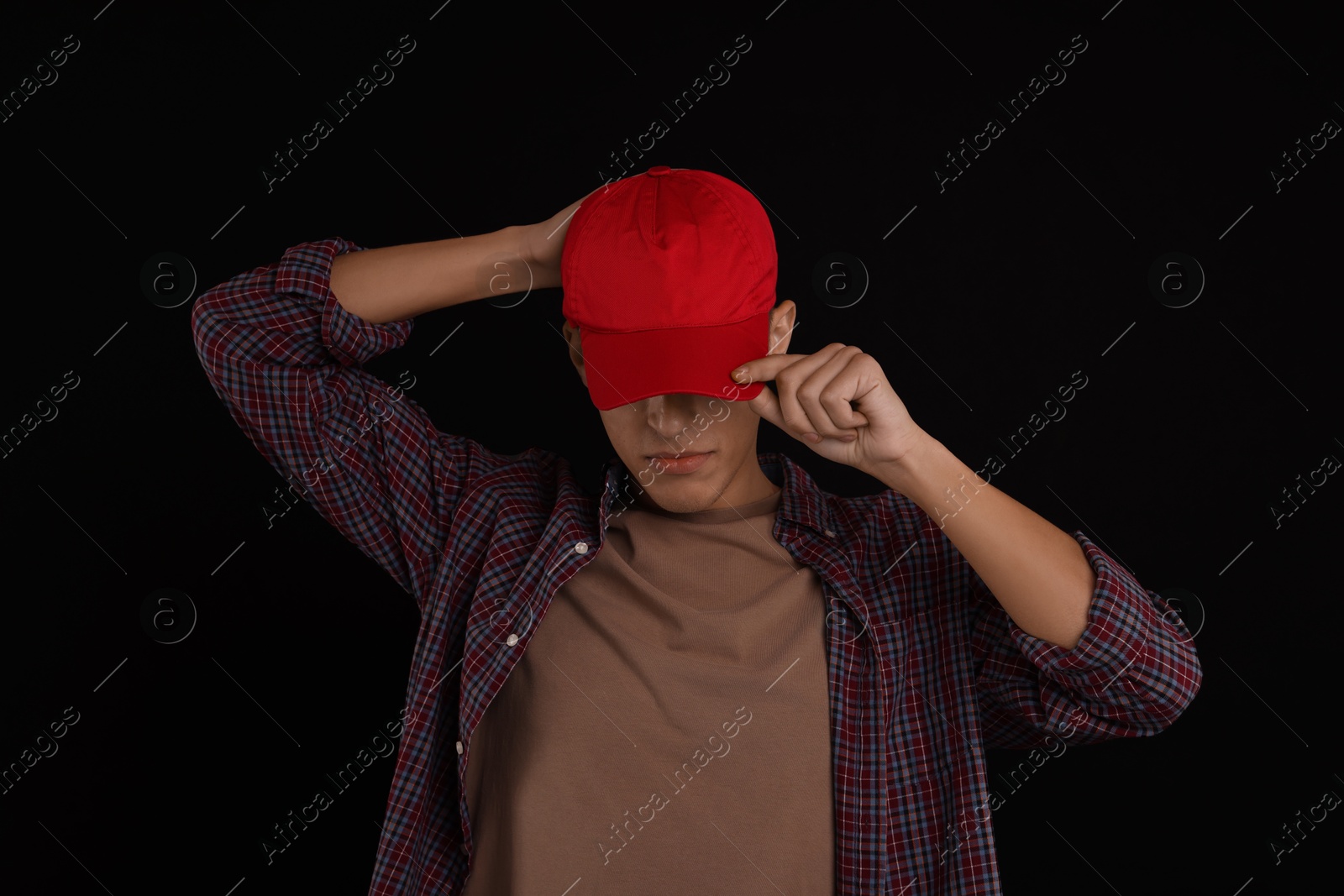 Photo of Man in stylish baseball cap on black background. Mockup for design