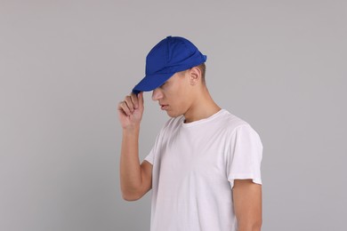 Photo of Man in stylish baseball cap on grey background. Mockup for design