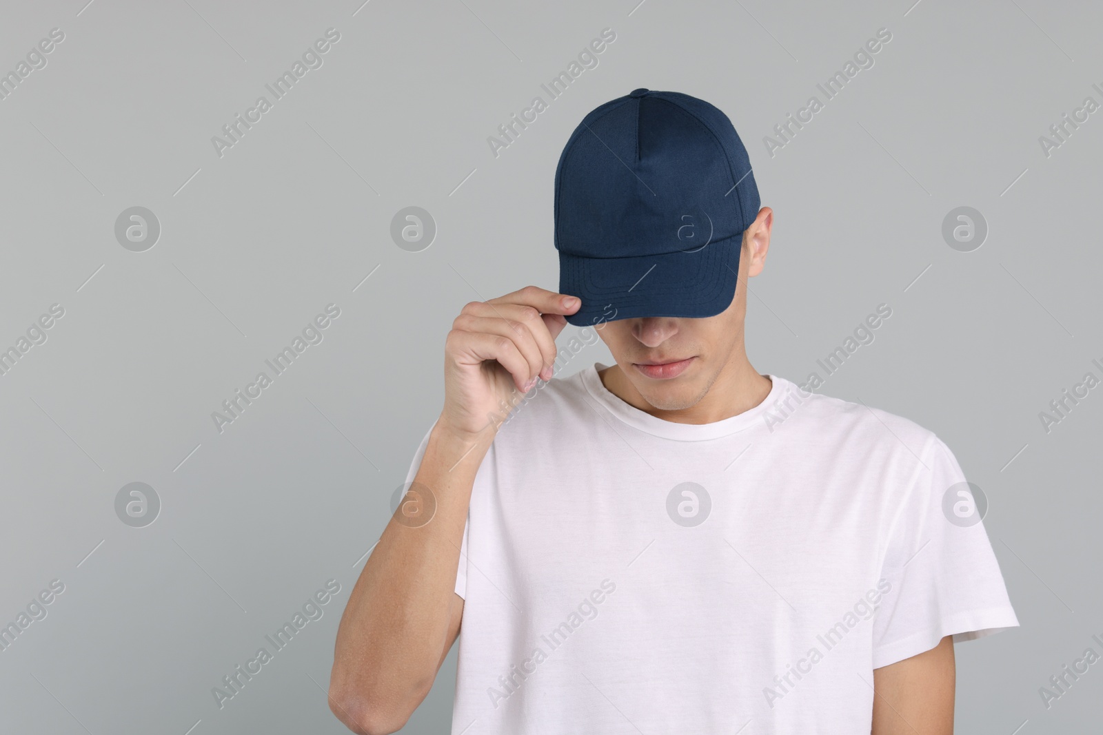 Photo of Man in stylish baseball cap on grey background. Mockup for design