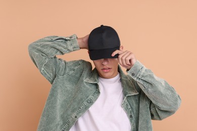 Photo of Man in stylish baseball cap on beige background. Mockup for design