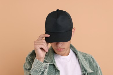 Photo of Man in stylish baseball cap on beige background. Mockup for design