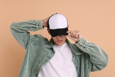 Photo of Man in stylish baseball cap on beige background. Mockup for design