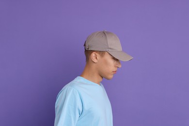 Photo of Man in stylish baseball cap on violet background. Mockup for design