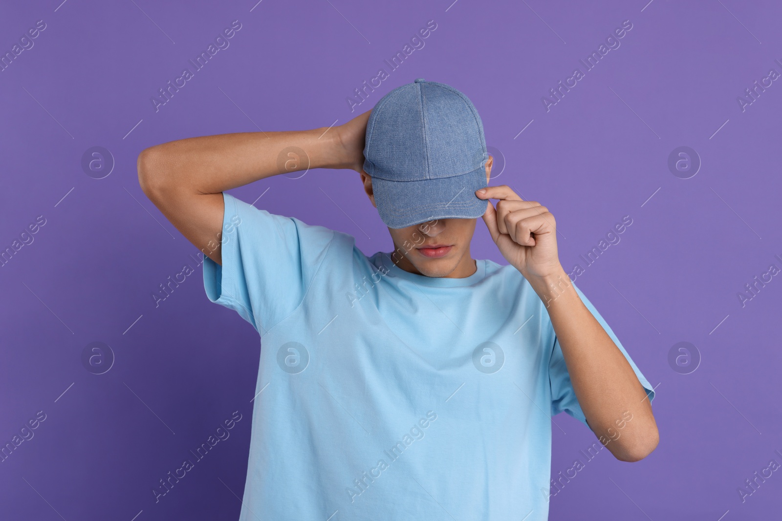 Photo of Man in stylish baseball cap on violet background. Mockup for design