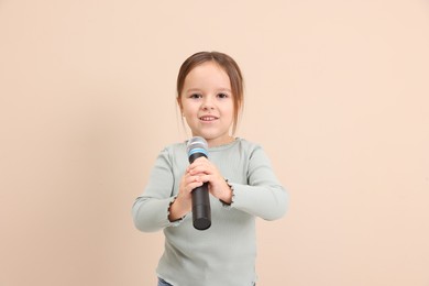 Photo of Smiling girl with microphone near beige wall