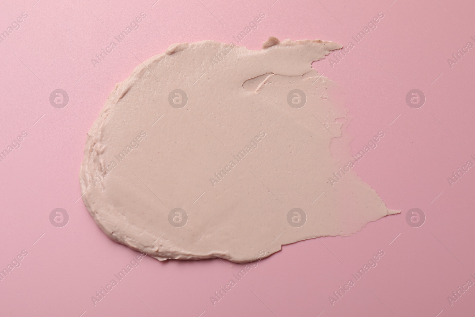 Photo of Cream on pink background, top view. Sample of cosmetic product