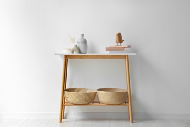 Photo of Stylish console table with decor near white wall indoors