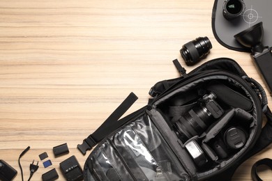 Photographer's equipment on wooden background, flat lay. Space for text