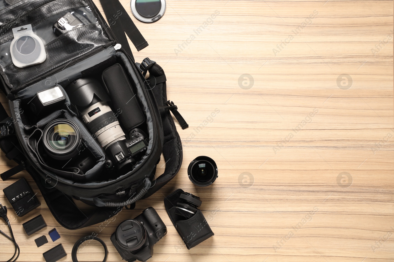 Photo of Photographer's equipment on wooden background, flat lay. Space for text