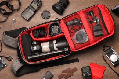 Photographer's equipment on wooden background, flat lay