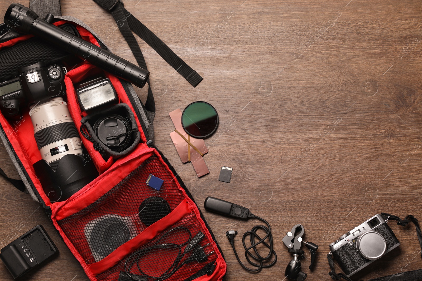 Photo of Photographer's equipment on wooden background, flat lay. Space for text