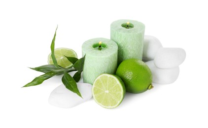 Photo of Spa composition with limes, massage stones, burning candles and green leaves isolated on white