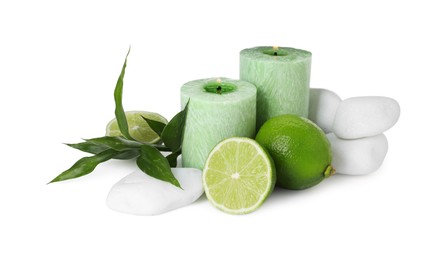 Photo of Spa composition with limes, massage stones, burning candles and green leaves isolated on white