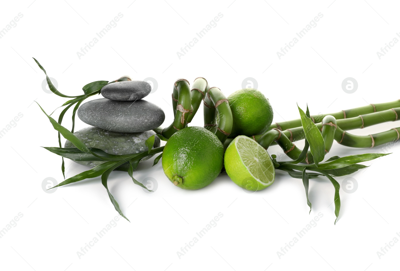Spa composition with limes, massage stones and bamboo stems isolated on white Photo of Spa composition with limes, massage stones and bamboo stems isolated on white