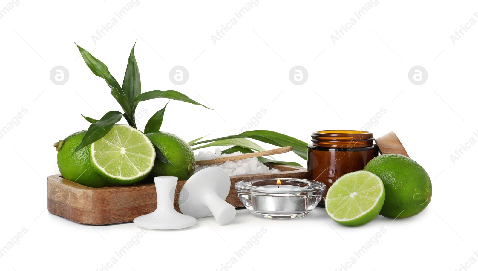 Spa composition with limes, massage stones, burning candle, sea salt and green leaves isolated on white Photo of Spa composition with limes, massage stones, burning candle, sea salt and green leaves isolated on white