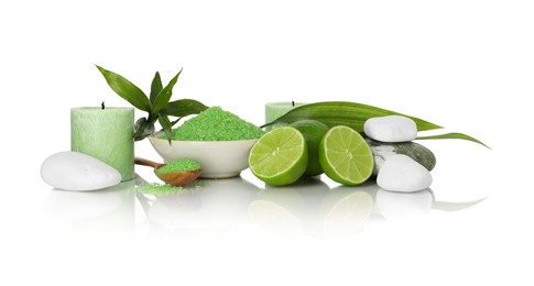Photo of Spa composition with fresh limes, sea salt, massage stones and bamboo leaves on mirror surface against white background
