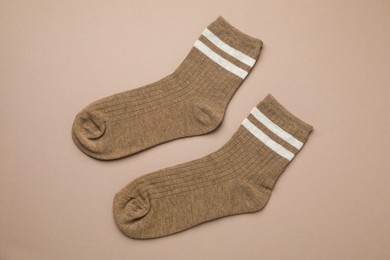 Photo of Pair of soft comfortable socks on brown background, top view