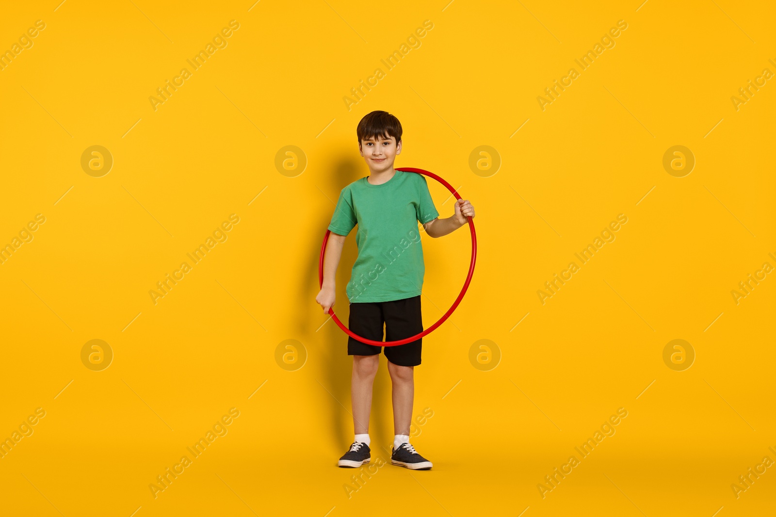 Photo of Boy with hula hoop on yellow background