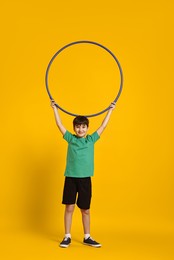 Photo of Boy with hula hoop on yellow background