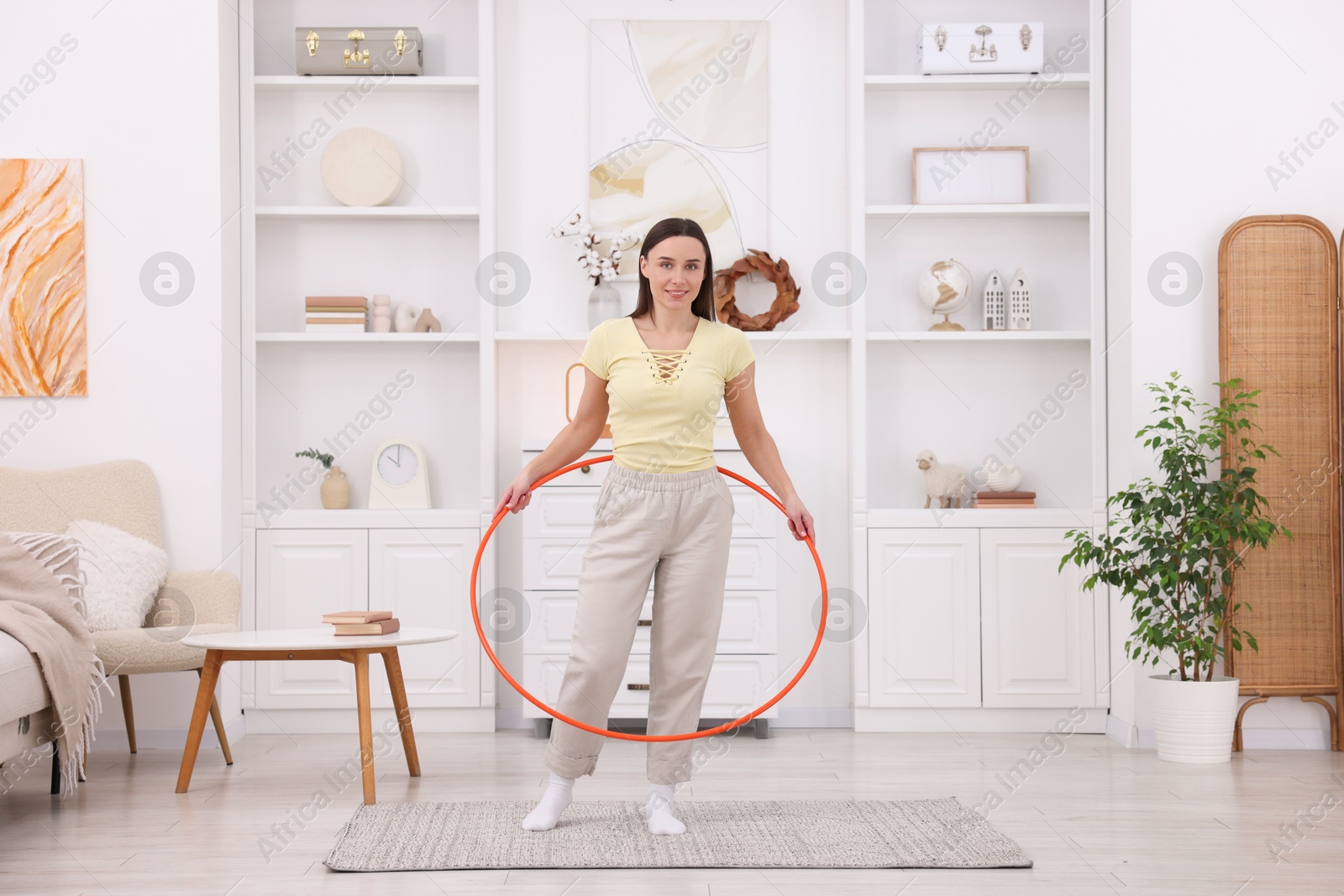 Photo of Smiling woman with hula hoop at home