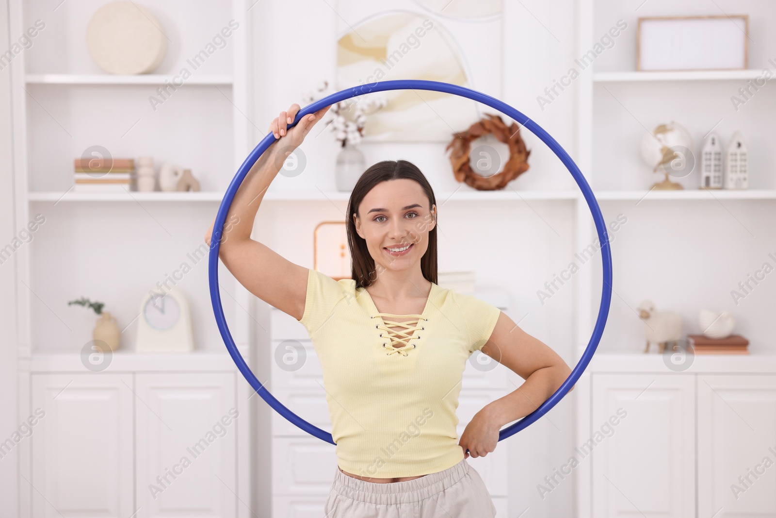 Photo of Smiling woman with hula hoop at home