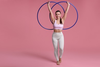 Photo of Smiling woman with hula hoops on pink background