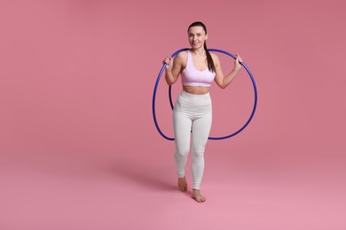 Photo of Smiling woman with hula hoops on pink background