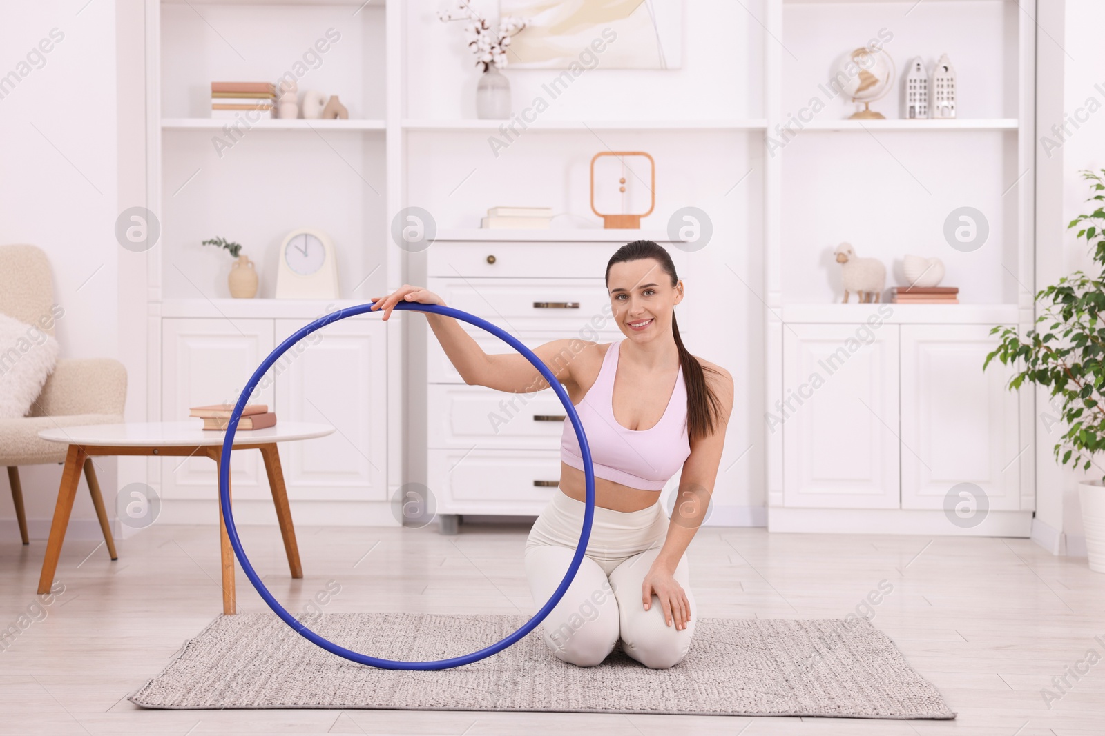 Photo of Smiling woman with hula hoop at home