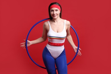 Photo of Smiling woman with hula hoop on red background