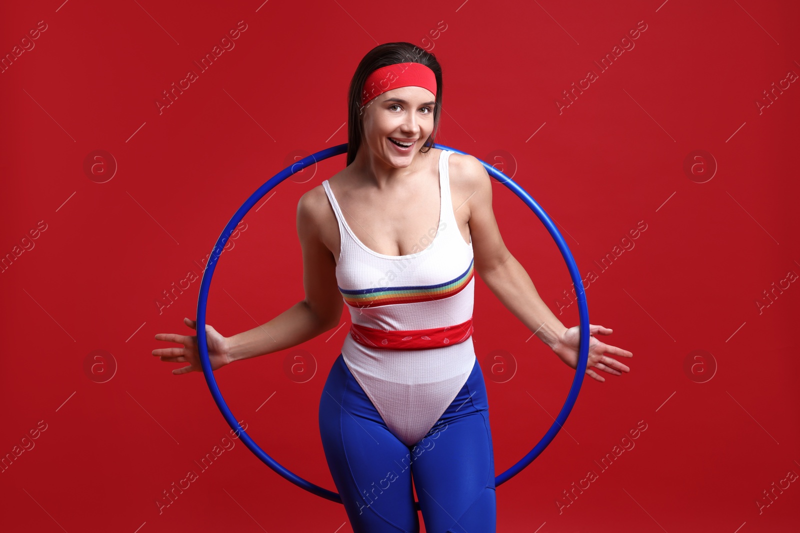 Photo of Smiling woman with hula hoop on red background