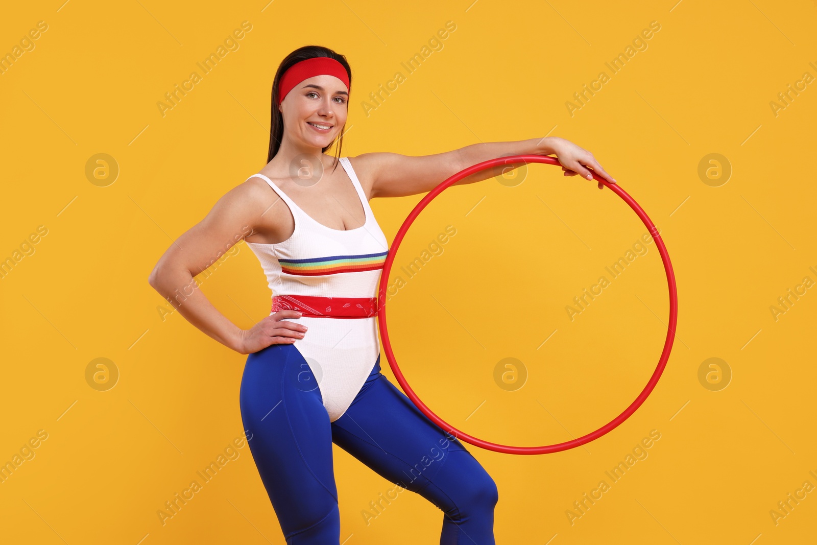 Photo of Smiling woman with hula hoop on orange background