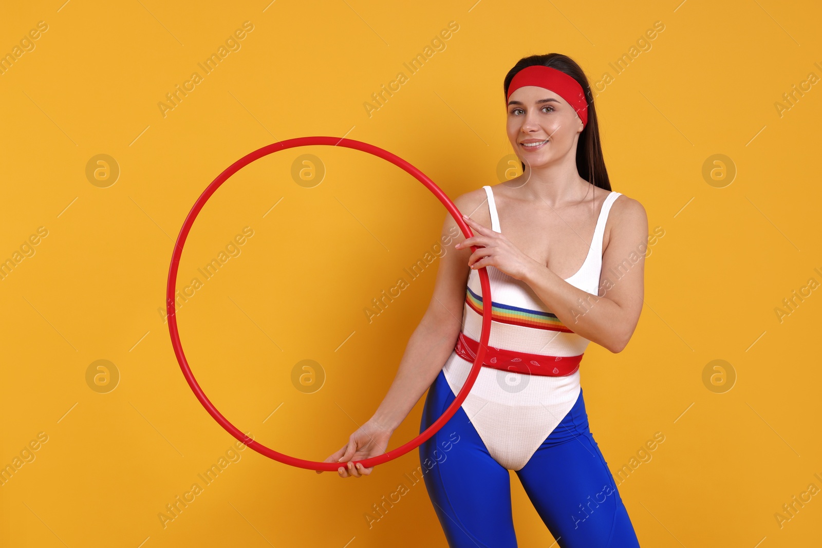 Photo of Smiling woman with hula hoop on orange background