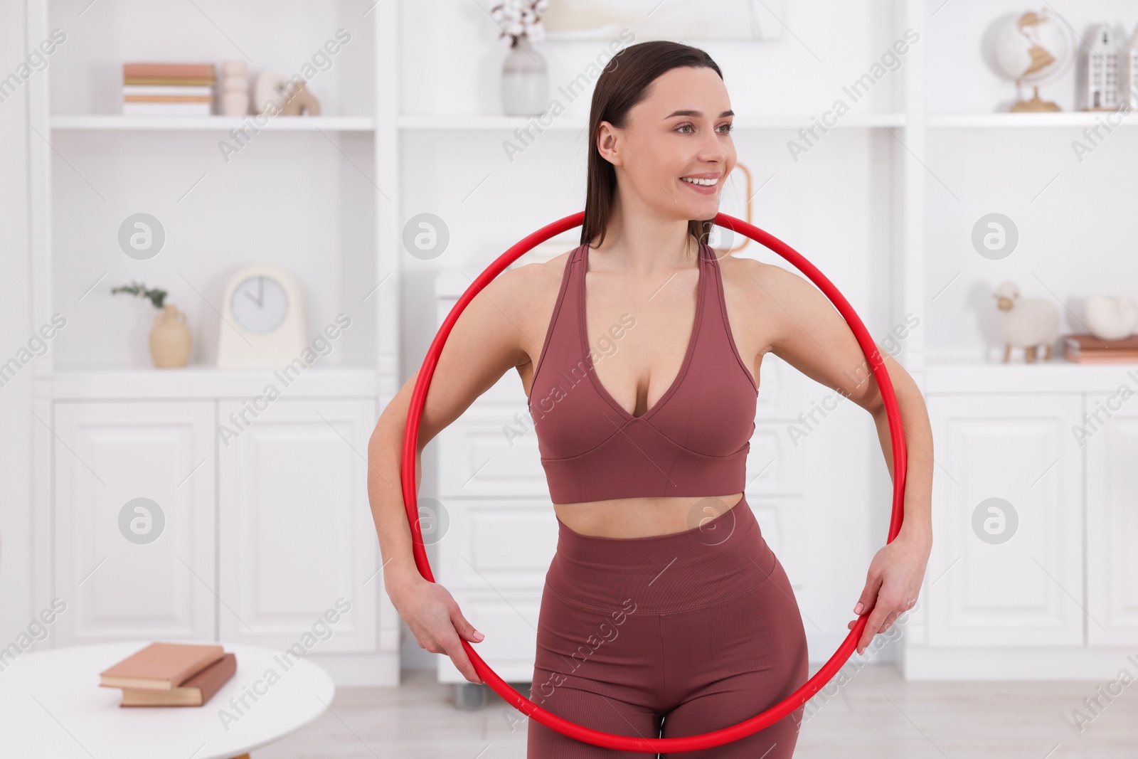 Photo of Smiling woman with hula hoop at home