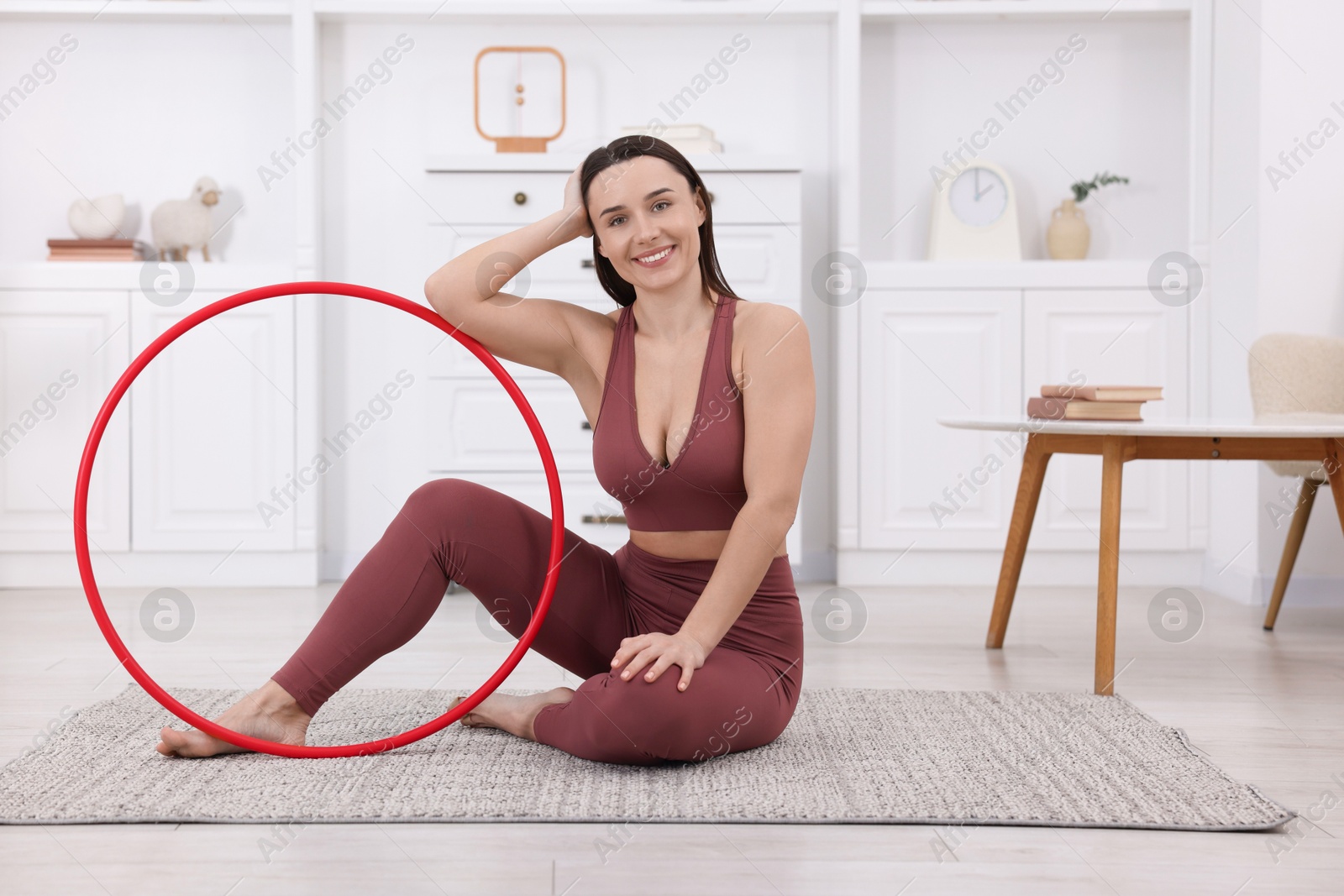 Photo of Smiling woman with hula hoop at home